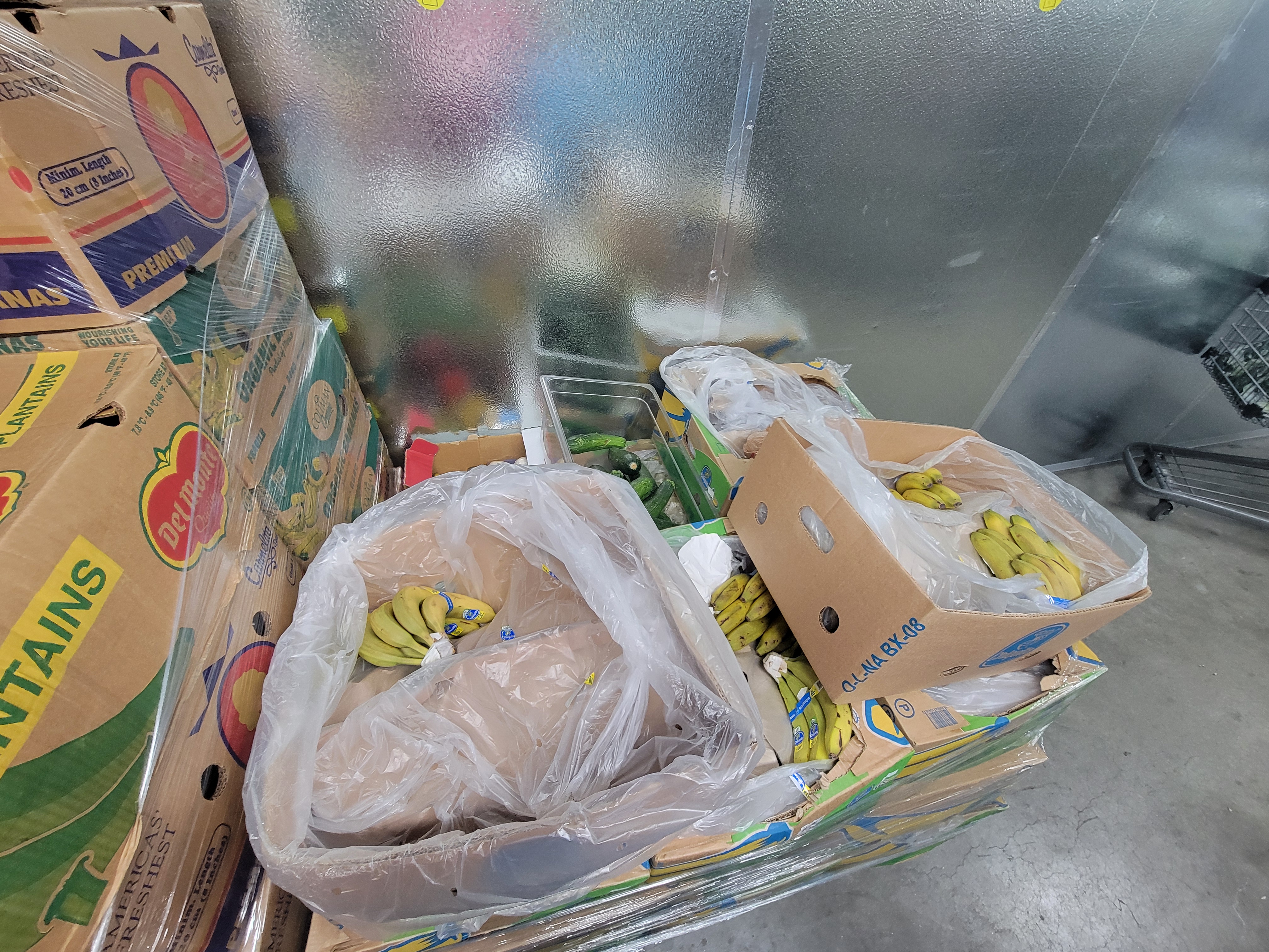 Pallets of produce filled banana boxes in plastic wrap.